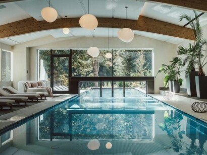 Il progetto architettonico valorizza il dialogo tra gli spazi interni e il paesaggio dolomitico, con ambienti dedicati al benessere e una vista privilegiata sul massiccio del Catinaccio. Ganis Resort, Nova Ponente Obereggen, Trentino Alto Adige, Italia