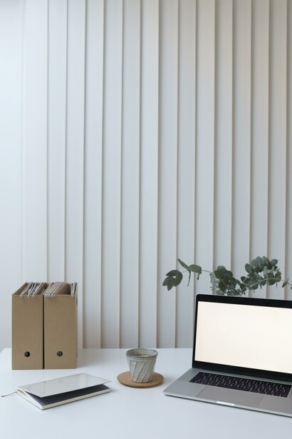Laptop on a table with some folders and a notebook