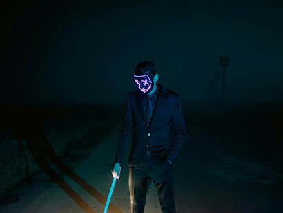 A masked individual represents the dark realities of cyber attacks