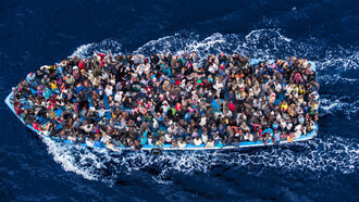 Italian navy rescues asylum seekers packed into a boat off the coast of Africa on the Mediterranean Sea