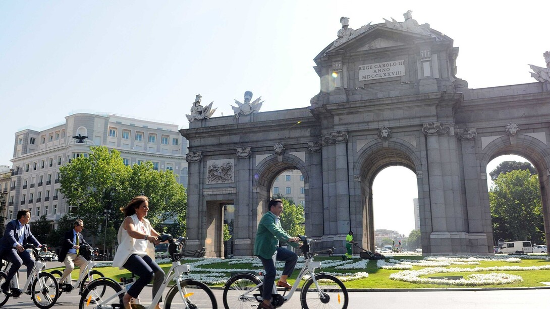 Paseando en bicicleta ante la Puerta de Alcalá de Madrid