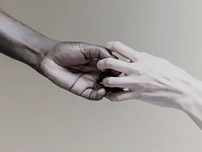 Two individuals, their hands intertwined, extending towards one another in a gesture of connection and unity