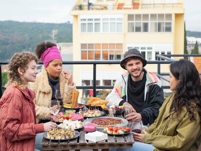 Solo travellers connecting over a communal table, reflecting the power of everyday moments to build authentic friendships