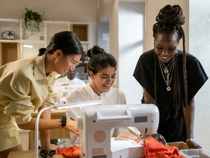 Female fashion students using sewing machines as part of their design training