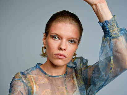 With a striking blouse and a blank stare, she represents the complex dialogue between art and artificial intelligence