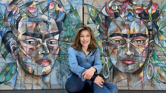 Frédérique Assaël frente a dos de sus retratos de Frida Kahlo