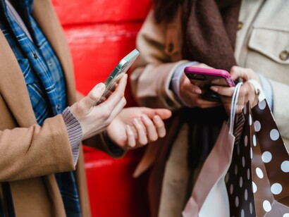 Two people holding mobile phones. Digital literacy should be combined with analysis and strategy