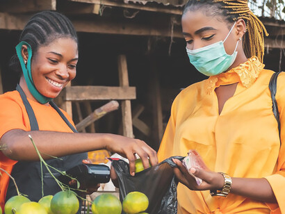 African woman vending fruits at a bustling market, showcasing economic vitality in Africa