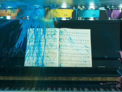 Captura de "Crush!" en la que la pintura de unas latas estalladas se derrama sobre un piano a punto de ser destruido
