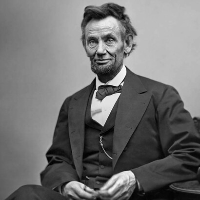 Abraham Lincoln, seduto e con in mano gli occhiali e una matita, 1865