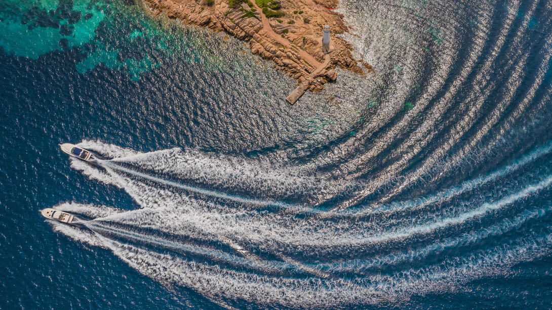 Luxury boats line the crystal-clear shores of Sardinia, Italy