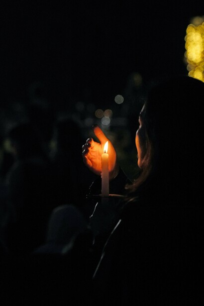 Woman holding a candle and blocking wind with hand