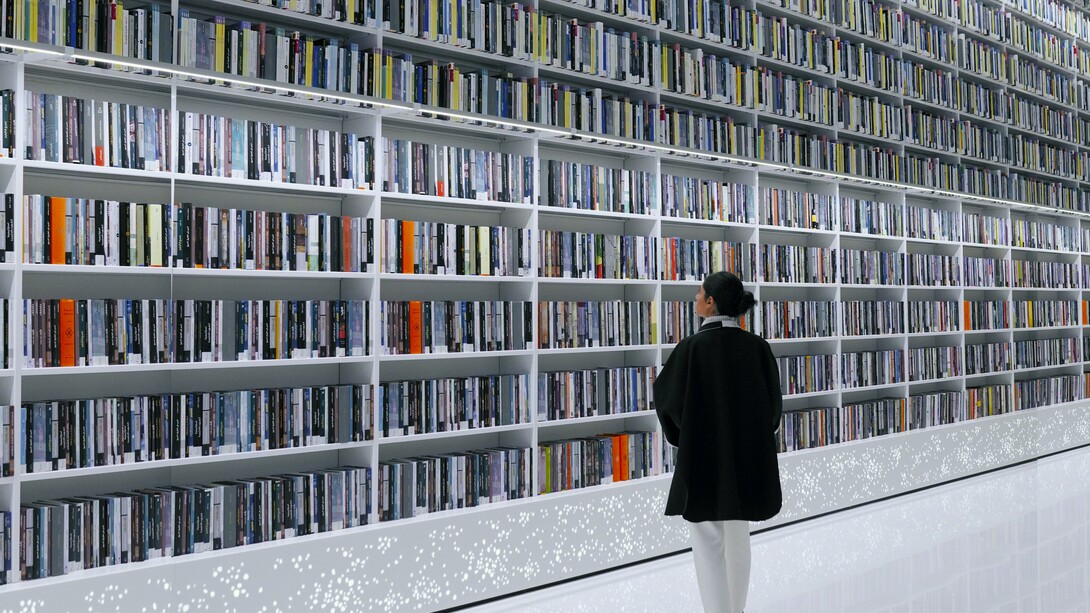 Mulher explora livros em estante de biblioteca