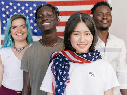 Jóvenes que presentan distintos rasgos étnicos  con una bandera de Estados Unidos. El Soft Power no es una característica única de una potencia liberal, sino que también fue utilizado por regímenes autoritarios