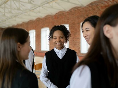 A group of students in school uniforms chatting in the basketball court
