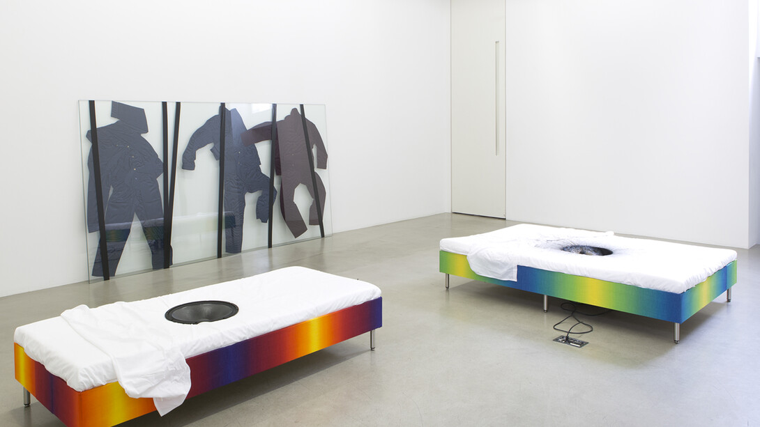 Lili Reynaud-Dewar, - Vivre avec ça ?!, 2014, Pyjamas d'homme, verre, ruban adhésif / Man's pyjamas, glass, tape, 165 x 300 x 2.5 cm, - Live Through that ?! , 2014, Lit, draps, haut-parleur, ampli, lecteur CD, mélodie (en boucle) / Bed, sheets, speaker, amplifier, CD player, looped audio (melody), 39.5 x 181 x 83 cm, - Live Through that ?!, 2014, Lit, draps, fontaine, encre / Bed, sheets, fountain, ink, 41.5 x 188 x 133.5 cm, Vue de l’exposition / Exhibition view « Vivre avec ça ?!», kamel mennour (47, rue saint-andré des arts), Paris, 2014, © Lili Reynaud-Dewar, © Photo. Fabrice Seixas, Courtesy the artist and kamel mennour, Paris