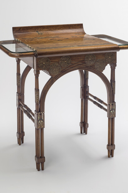 Eugenio Quarti (1867-1929), Bureau-coiffeuse, vers 1898, Noyer incrusté de filets de laiton et nacre formant un décor floral, deux tiroirs latéraux pivotans sous tablette de cristal. Pieds en colonnette regroupés par trois et reliés en façade par deux cerceaux et deux traverses tournées latérales, H. 0,785 x L. 0,53 x P. 0,795, Paris, Musée d'Orsay
© Musée d'Orsay, Dist. RMN-Grand Palais / Patrice Schmidt