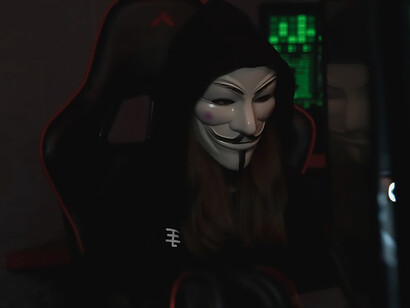 Cloaked in a Vendetta mask, a hacker conducts unlawful activities on a computer