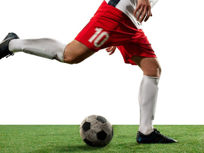 A football player executes a dynamic move on a white background