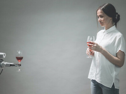 A woman gracefully holds a glass of wine, engaging in a captivating interaction with an AI-powered robot