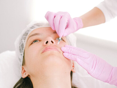 A woman receiving Botox injections from a doctor at a cosmetic clinic