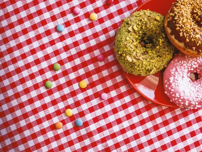 A picnic tablecloth with sweets and doughnuts to remind us of our liberating childhood