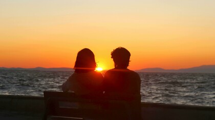 Casal assiste o atardecer juntos