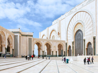 Visitors walking through the vast courtyard of the Hassan II Mosque, reflecting Morocco’s openness and shared public life