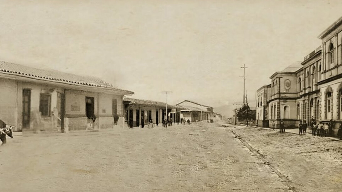 Composición fotográfica elaborada a partir de la fusión de tres imágenes antiguas de Cartago, tomadas antes del terremoto de 1910. La fotografía de la izquierda, capturada por Philip y Amelia Calvert, muestra la casa tradicional de Anacleta, cuando albergaba la tienda El Irazú de don Felipe Martín en 1910. Las otras dos, de autor desconocido, corresponden a la Escuela de Párvulos y al hotel Estrella del Norte (a la derecha). Fusión fotográfica realizada por Florentino Leiva Ortega, 2025