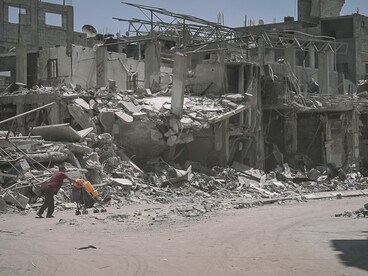 Following heavy bombing in 2024, buildings in Gaza lie in rubble as people navigate the devastation and struggle to survive among the ruins