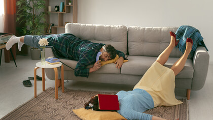 Husband and wife living a sedentary lifestyle, lounging on the couch with little movement