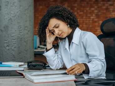 A professional overwhelmed by workplace pressure at her desk, symbolizing how stress can instantly alter our breathing