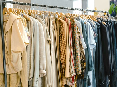 Várias roupas expostas em cabideiro na loja