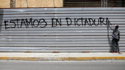 Joven manifestante pinta un grafiti durante el paro general contra el régimen de Nicolás Maduro en Caracas, Venezuela