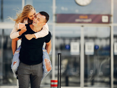 A beautiful couple standing at the airport, sharing a kiss during their reunion after moving abroad for love