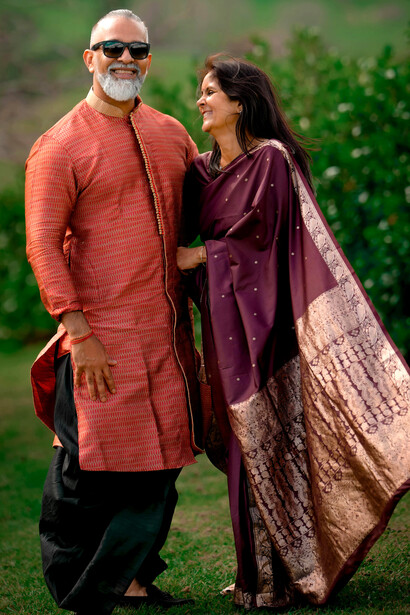 A joyful elderly Indian couple, dressed in traditional clothing, smiles warmly as they enjoy a quiet moment together