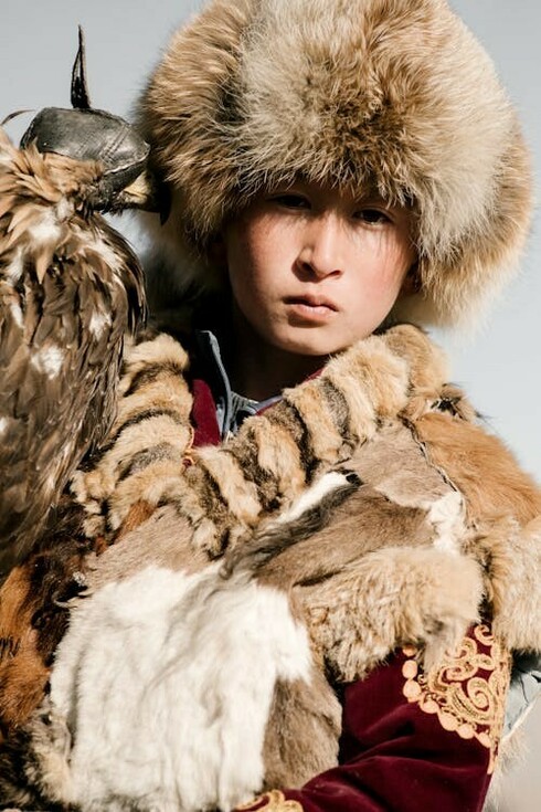 Mongolia's nomadic community adorned in traditional garments, skillfully mounted on horseback