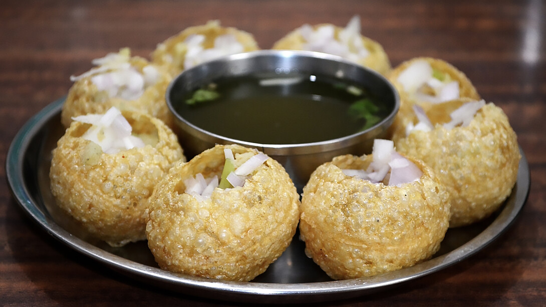 Panipuri—also known as golgappa, gappa, fuchka, phuchka, phuska, puska, batashe, padake, fulki, pakodi, or jalpooree—is a deep-fried, hollow, and crispy spherical shell, about 1 inch (25 mm) in diameter, traditionally filled with a mixture of potatoes, raw onions, chickpeas, and spices
