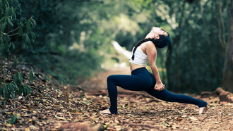 Giovane donna che esegue una variante di Viparita Virabhadrasana (posizione del guerriero rovesciato). Attraverso lo yoga si possono attivare stratagemmi per la mente ansiosa