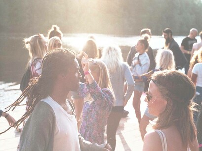A party nearby a lake with people dressed in western clothing as opposed to traditional African ones is a sign of a cultural shift