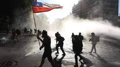 Ciudadanos chilenos entre el gas lacrimógeno en una protesta a favor de un cambio Constitucional en Chile