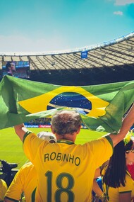 Torcedor levanta a bandeira do Brasil no estádio do Maracanã no Rio de Janeiro enquanto veste a camisa do jogador Robinho