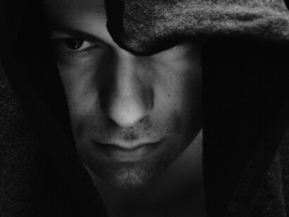 A black-and-white image of a man, reflecting themes of loneliness, isolation, and incel culture
