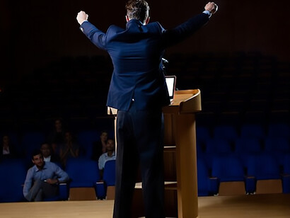 A male politician delivering an impassioned speech, seeking to captivate the audience's attention