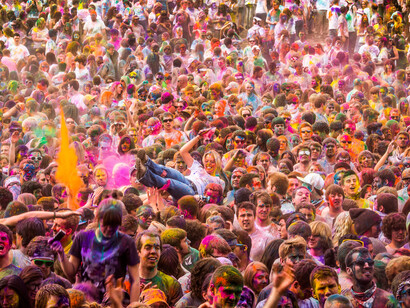The massive crowd at the festival exemplifies the powerful influence of communal enthusiasm, reflecting the tendency for people to flock together despite the personal inconvenience