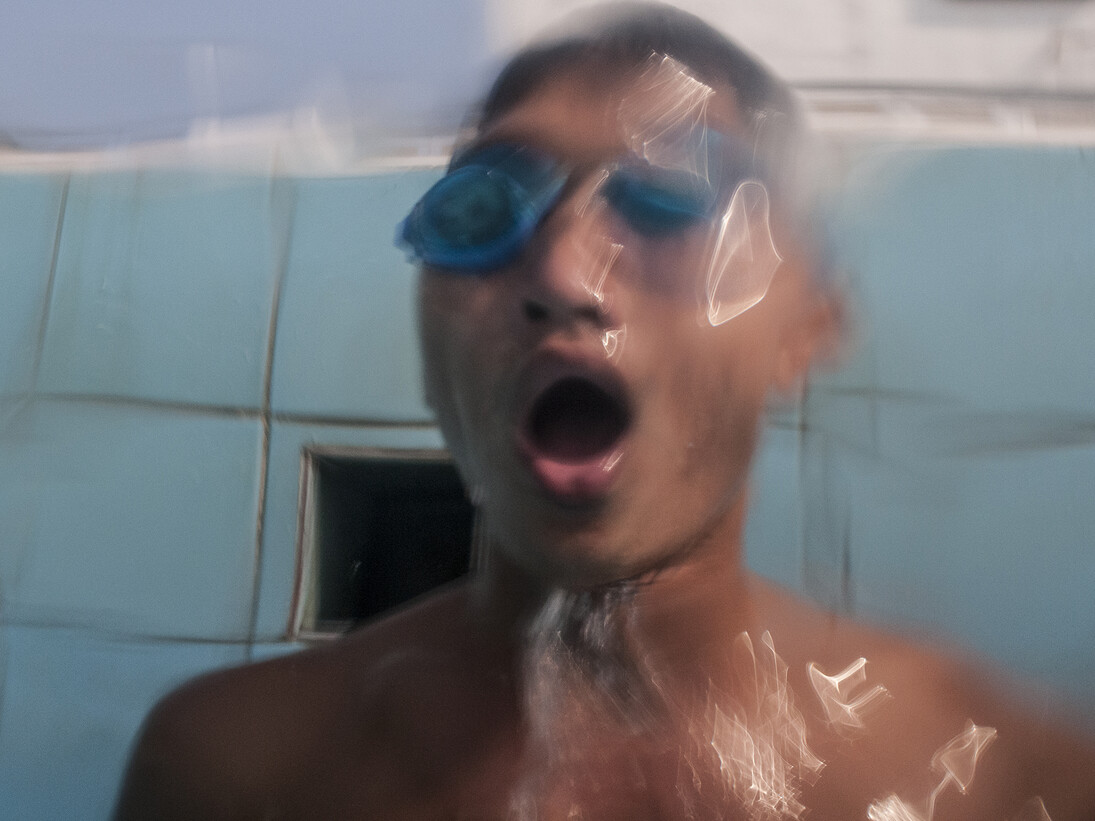 UXO salvage diver Piseth Dara (24) emerges from underwater in
the Olympic swimming pool
in Phnom Penh,Cambodia. Prior to the diver training the majority
of the team had basic swimming skills, now they are all strong
swimmers due to the intense nature of the training required to be a
salvage diver