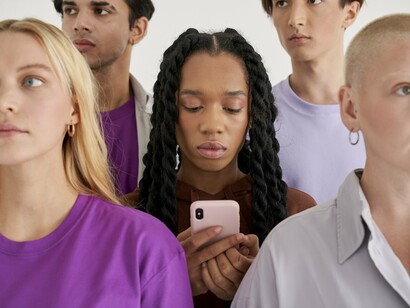 Jovem observa seu telefone apreensivamente. Navegamos numa maré paradoxal, acreditamos que tudo é um dado adquirido, enquanto somos assombrados por arquétipos inalcançáveis e metas idealizadas