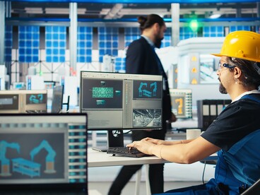 Factory engineer using AI to optimise solar panel efficiency under human oversight