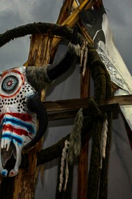 A ceremonial bull skull fixed upon a rustic wooden frame beneath a turbulent sky in Mexico, reflecting the lingering presence of ancestral belief systems