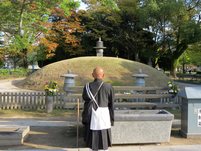 Un monje reza frente al Montículo funerario conmemorativo de la bomba atómica en Hiroshima, Japón